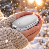 Hands holding the hand warmer outdoors in the snow